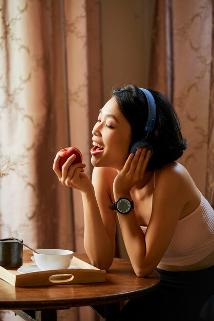 Hübsche Frau, die saftigen Apfel isst