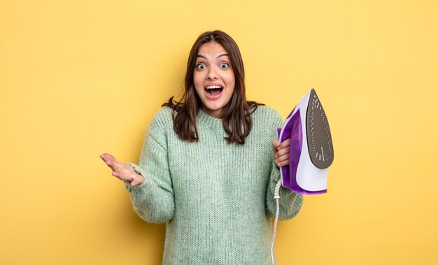 Hübsche Frau, die sich extrem schockiert und überrascht über das Konzept der Eisenkleidung fühlt