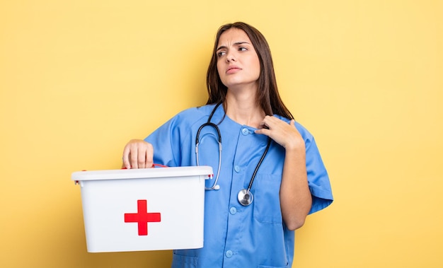 Foto hübsche frau, die sich gestresst, ängstlich, müde und frustriert fühlt. krankenschwester mit mit einer erste-hilfe-ausrüstung krankenschwester