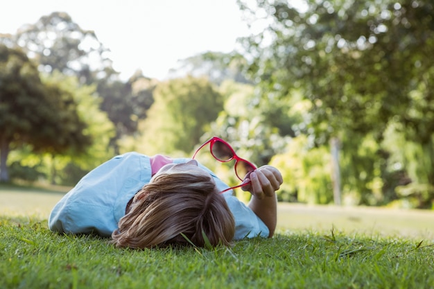 Hübsche Frau, die sich im Park hinlegt