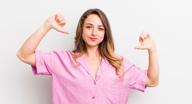 Hübsche Frau, die sich stolz, arrogant und selbstbewusst fühlt und zufrieden und erfolgreich auf sich selbst zeigt