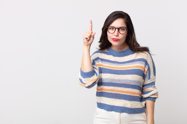 hübsche Frau, die sich wie ein Genie fühlt, die stolz den Finger in die Luft hält, nachdem sie eine großartige Idee realisiert hat, und sagt Heureka