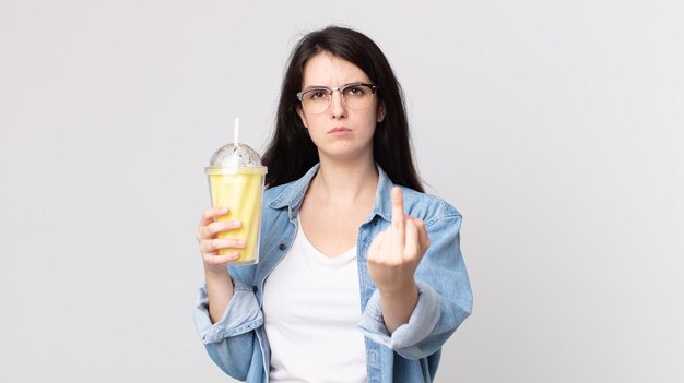 Foto hübsche frau, die sich wütend, verärgert, rebellisch und aggressiv fühlt und einen vanille-milchshake hält