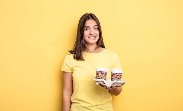 Hübsche Frau, die verwirrt und verwirrt aussieht, Kaffee zum Mitnehmen