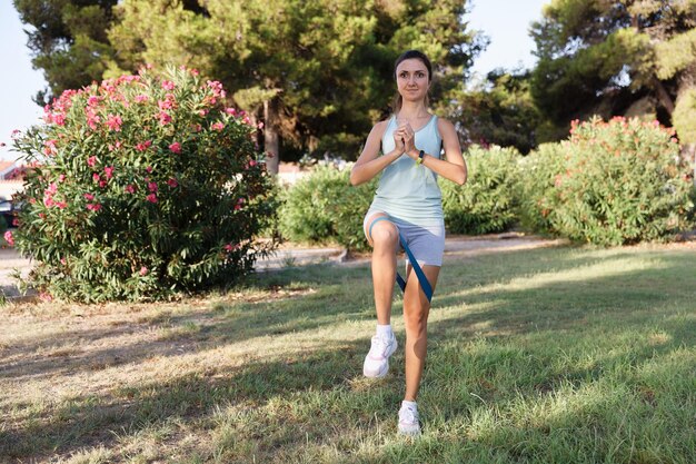 Hübsche Frau, die Yoga im Morgenpark tut Gesunder Lebensstil im Freien Konzeption Sport Frau Naturporträt Übungen Gesunder Lebensstil