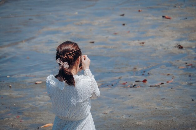 Hübsche Frau hell, Fotos, entlang dem Strand morgens machend.