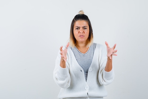 Hübsche Frau im T-Shirt, Strickjacke mit Größenschild und verwirrtem Blick