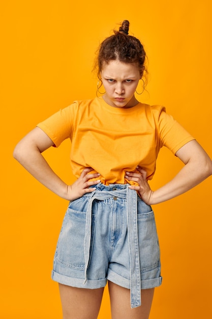 Hübsche Frau in einem gelben T-Shirt, das Emotionen aufwirft, isolierte Hintergründe unverändert