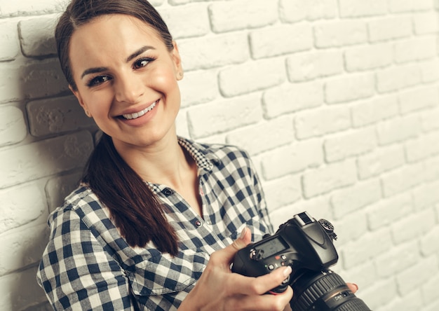 Hübsche Frau ist ein professioneller Fotograf mit DSLR-Kamera