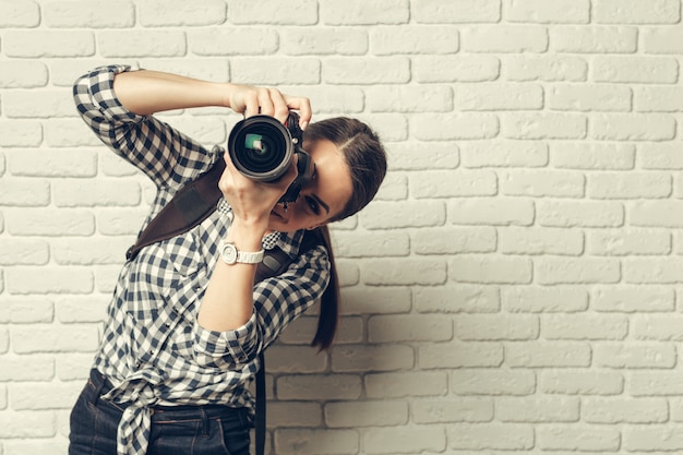 Hübsche Frau ist ein professioneller Fotograf mit DSLR-Kamera