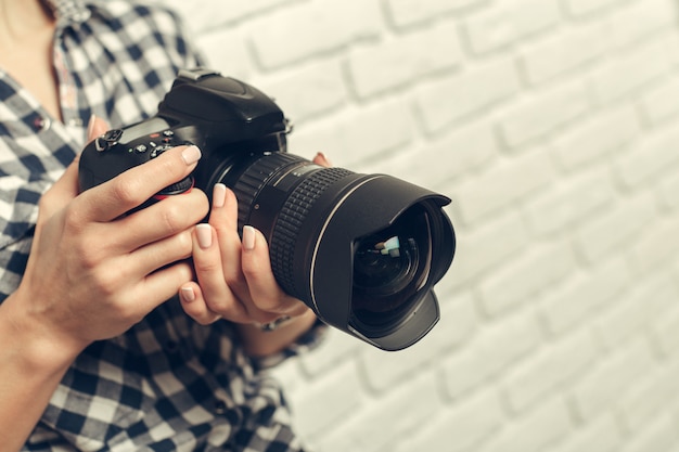 Hübsche Frau ist ein professioneller Fotograf mit DSLR-Kamera