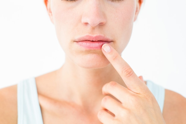 Hübsche Frau mit dem Finger auf Lippe