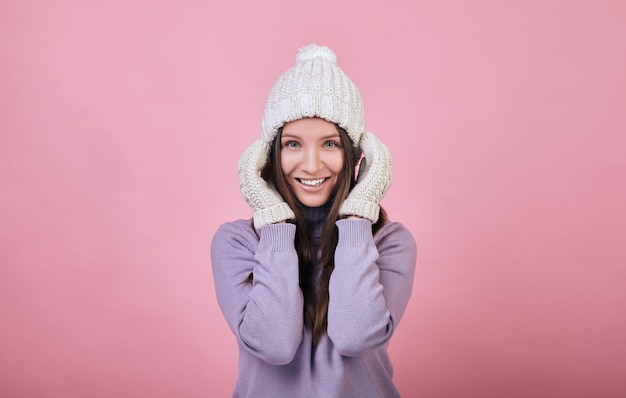 Hübsche Frau mit grünen Augen auf einer weißen Strickmütze des Winters