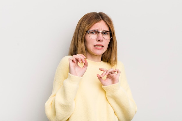 Foto hübsche frau mit rotem kopf, die sich angewidert und übel fühlt, wenn sie sich von etwas bösem, stinkendem oder stinkendem zurückzieht und igitt sagt