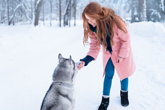 Hübsche Frau mit verspieltem Husky-Hund