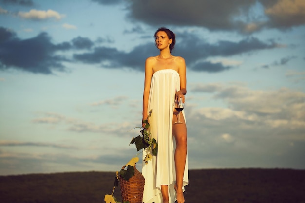 Hübsche Frau mit Wein über dem Himmel