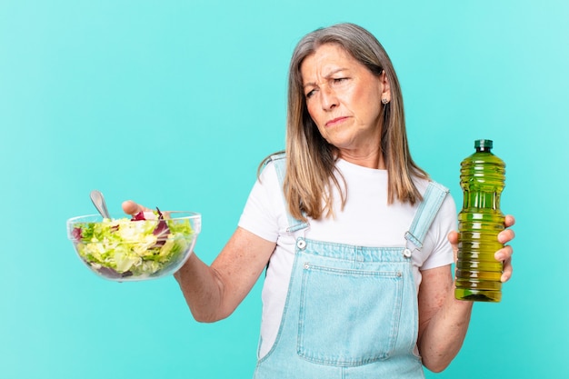 Hübsche Frau mittleren Alters, die einen Salat isst.