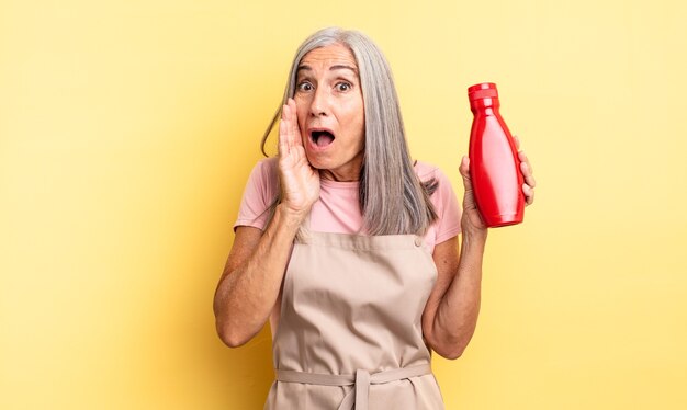 Hübsche Frau mittleren Alters, die sich schockiert und verängstigt fühlt. Ketchup-Konzept