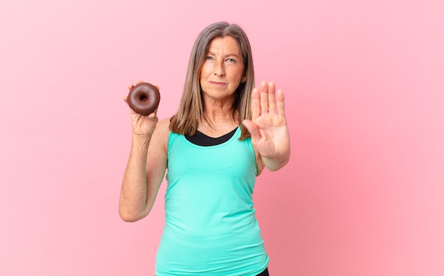 Hübsche Frau mittleren Alters mit einem Donut