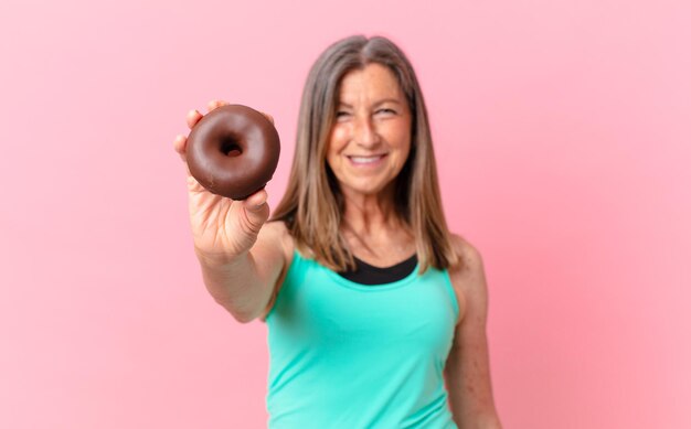 Hübsche Frau mittleren Alters mit einem Donut