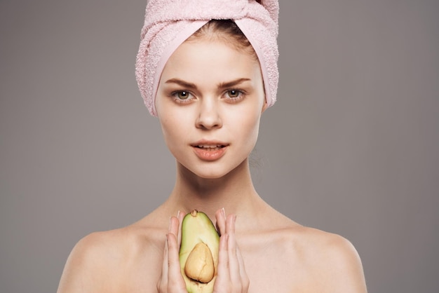 Hübsche Frau nackte Schultern Avocado grauer Hintergrund