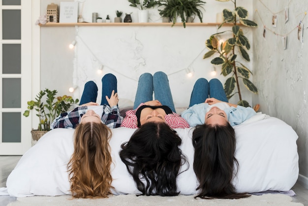 Hübsche Frauen, die auf Bett liegen