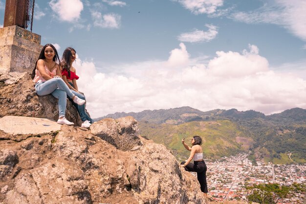 Hübsche Frauen genießen und fotografieren auf dem Gipfel des höchsten Berges in Jinotega Nicaragua unter dem blauen Himmel und der Stadt im Hintergrund