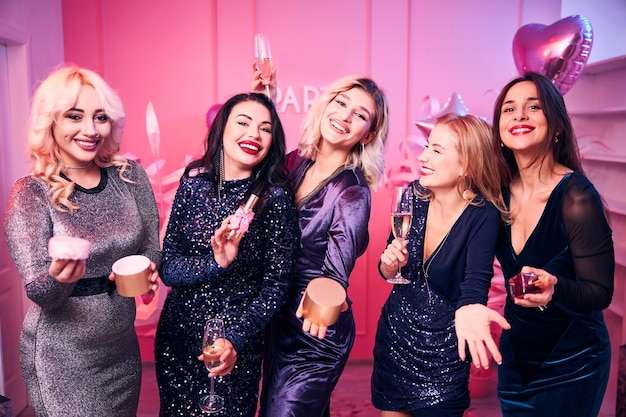 Hübsche Frauen in Cocktailkleidern lachen herzlich