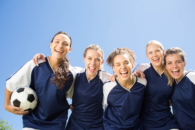 Foto hübsche fußballspieler, die an der kamera lächeln