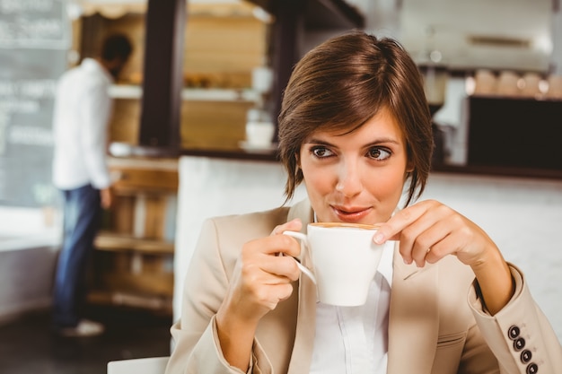 Hübsche Geschäftsfrau, die ihren Kaffee genießt