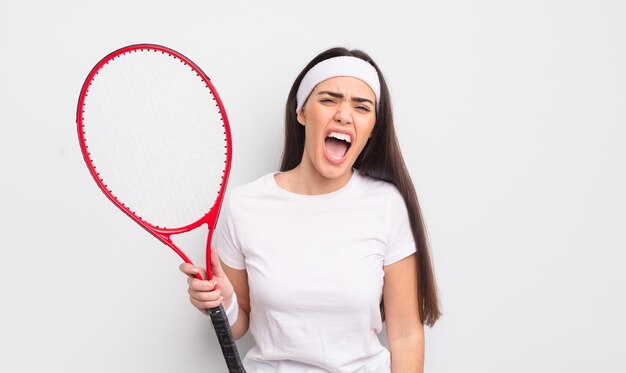 Hübsche hispanische Frau, die aggressiv schreit und sehr wütend aussieht Tenniskonzept