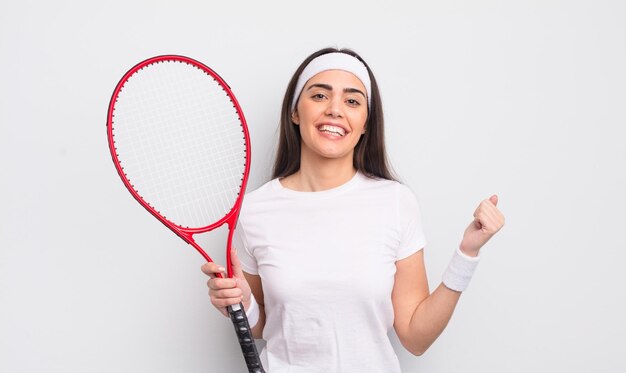 Hübsche hispanische frau, die sich schockiert fühlt, lacht und erfolgs-tennis-konzept feiert