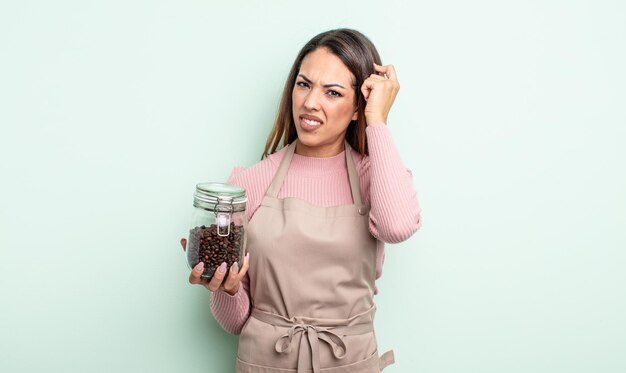 Hübsche hispanische Frau, die sich verwirrt und verwirrt fühlt und zeigt, dass Sie verrückt sind. Kaffeebohnen-Konzept