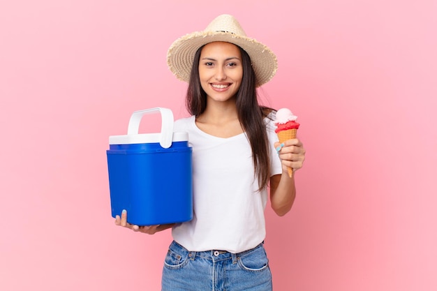 Hübsche hispanische Frau mit einem tragbaren Gefrierschrank und einem Eis