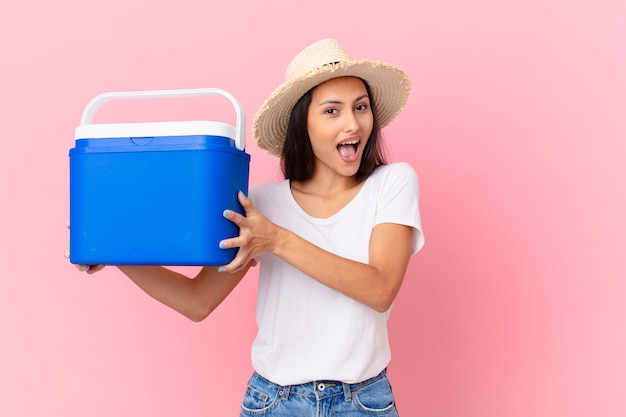 Hübsche hispanische Frau mit einem tragbaren Gefrierschrank