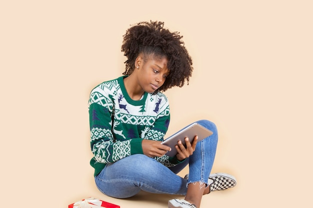 Hübsche hispanische lateinische frau mit weihnachtskleidung und einem tablet