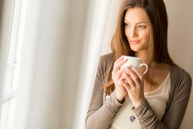 Hübsche junge Frau am Fenster