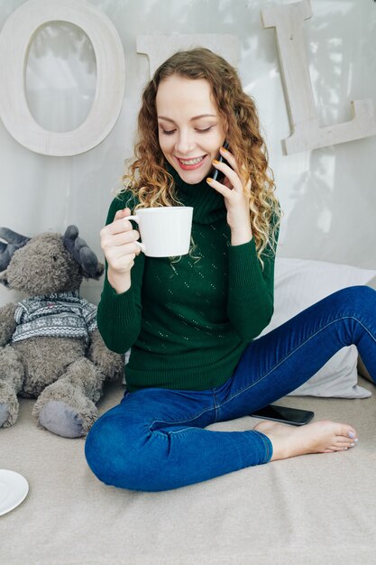 Hübsche junge Frau, die am Telefon spricht