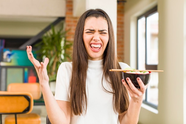 Hübsche junge Frau, die chinesische Ramen-Nudeln isst, schüsseln Haus Innenarchitektur