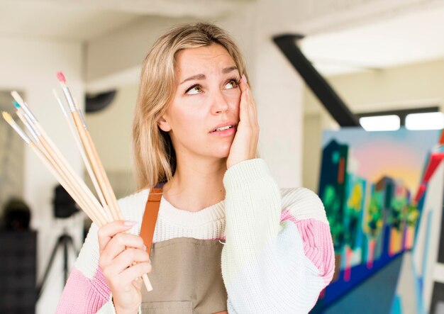 Foto hübsche junge frau, die ein kunstwerk künstler konzept haus innenarchitektur malt