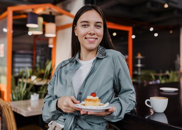 Hübsche junge Frau, die eine Kaffeepause genießt