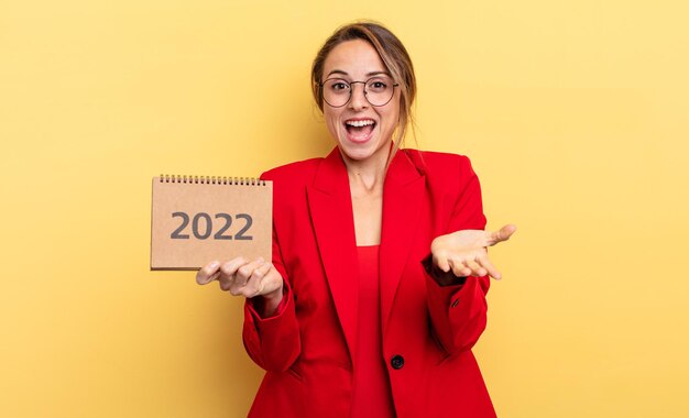 Hübsche junge Frau, die einen Kalender 2022 hält