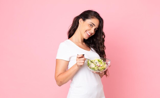 Hübsche junge Frau, die einen Salat zubereitet