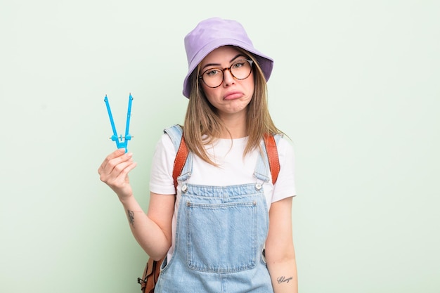 Hübsche junge Frau, die sich traurig und weinerlich fühlt, mit einem unglücklichen Blick und Weinen. studentisches Konzept