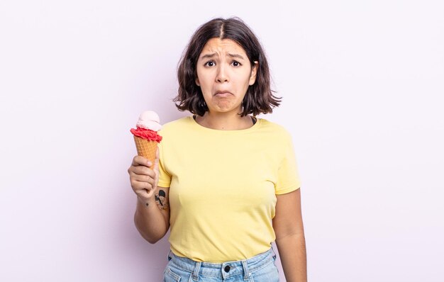 Hübsche junge Frau, die sich traurig und weinerlich mit einem unglücklichen Blick und Weinen fühlt. Eiskonzept