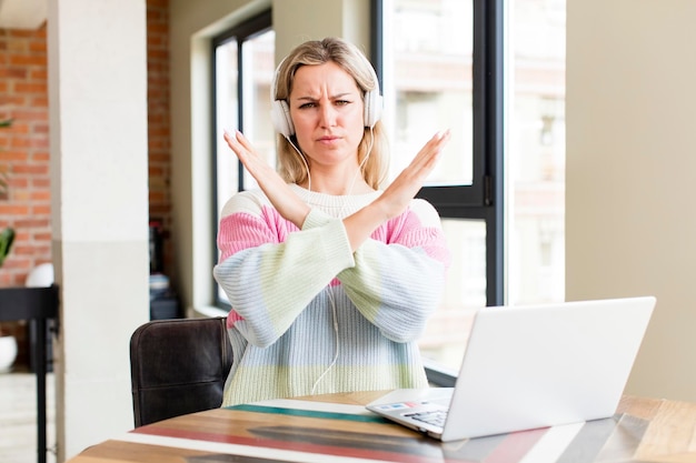 Hübsche junge Frau, die zu Hause mit der Innenarchitektur eines Laptophauses arbeitet