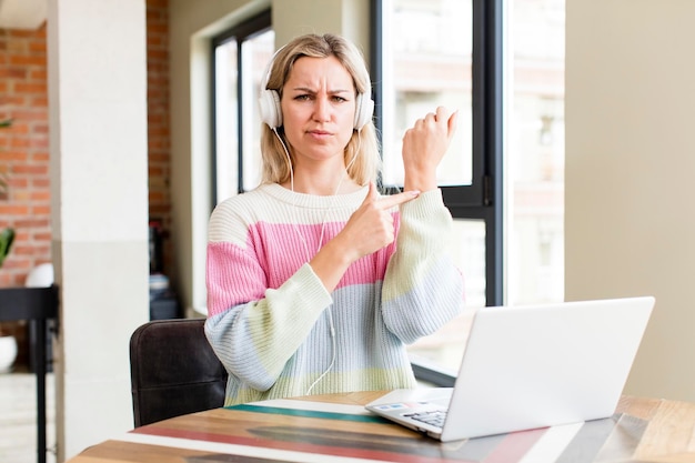 Hübsche junge Frau, die zu Hause mit der Innenarchitektur eines Laptophauses arbeitet