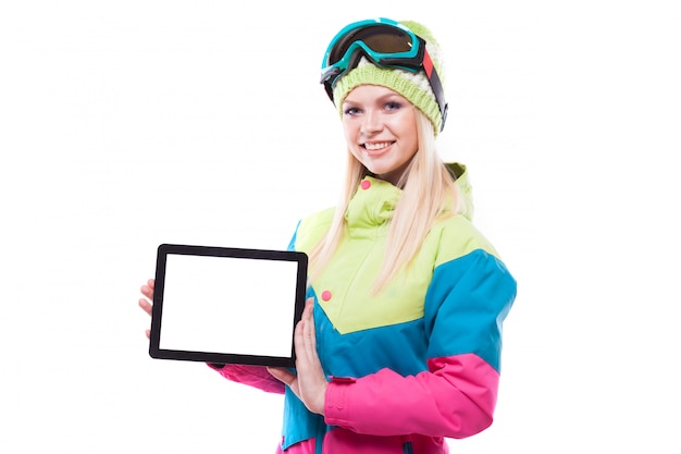 hübsche junge Frau im Ski-Outfit und Skibrille halten leere Tablette