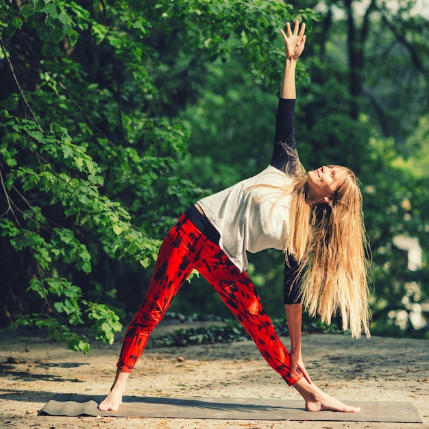 Hübsche junge Frau macht Yoga im Park