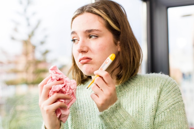 Foto hübsche junge frau mit einem thermometer grippekonzept haus innenarchitektur